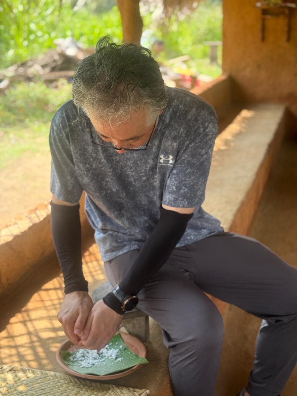 A traveller learning to prepare coconut sambol by hand