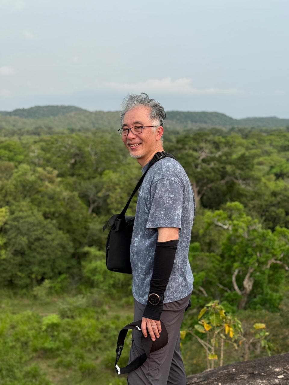 A traveller at a jungle viewpoint overlooking the dry-zone forest