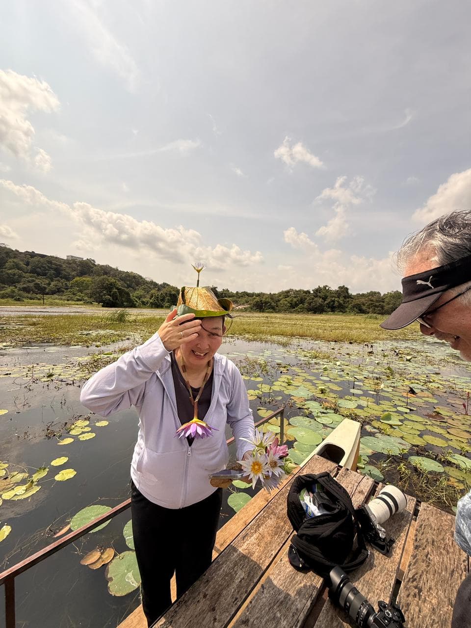 A traveller wearing a lotus-leaf hat on a lily pond boat trip