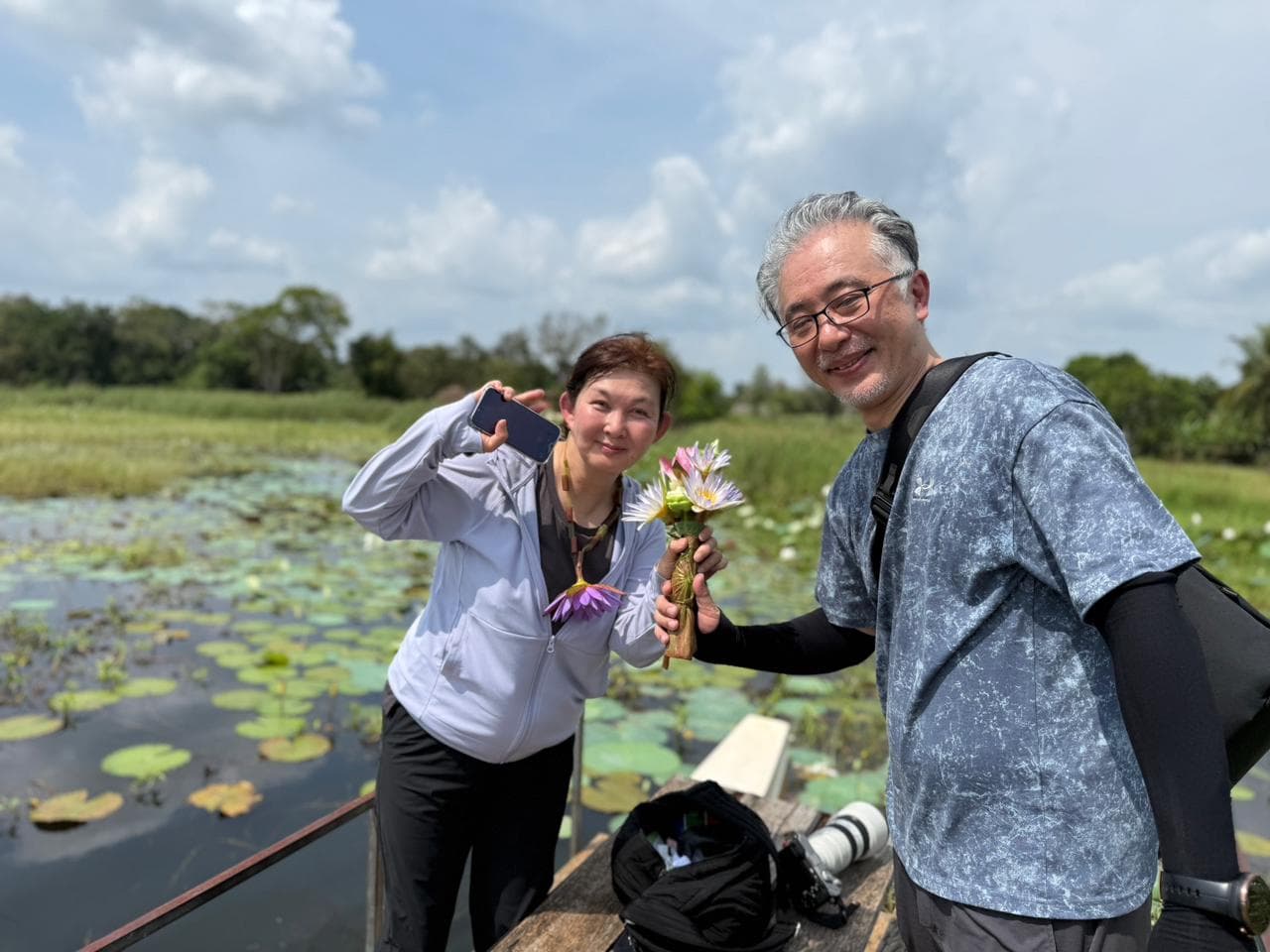 Travellers on a small boat picking flowers on a lily pond