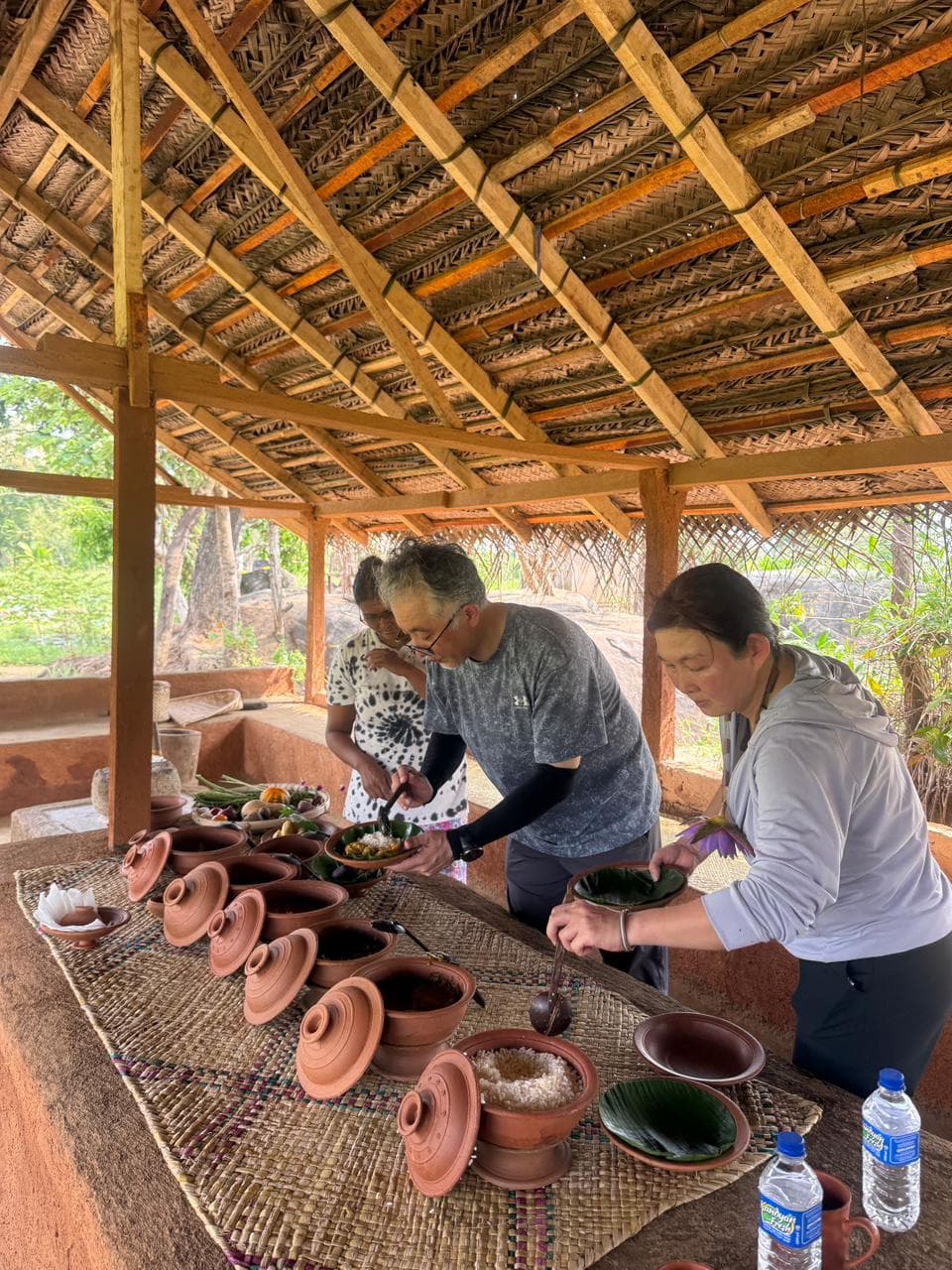 A traditional Sri Lankan rice and curry lunch served in clay pots on a village table