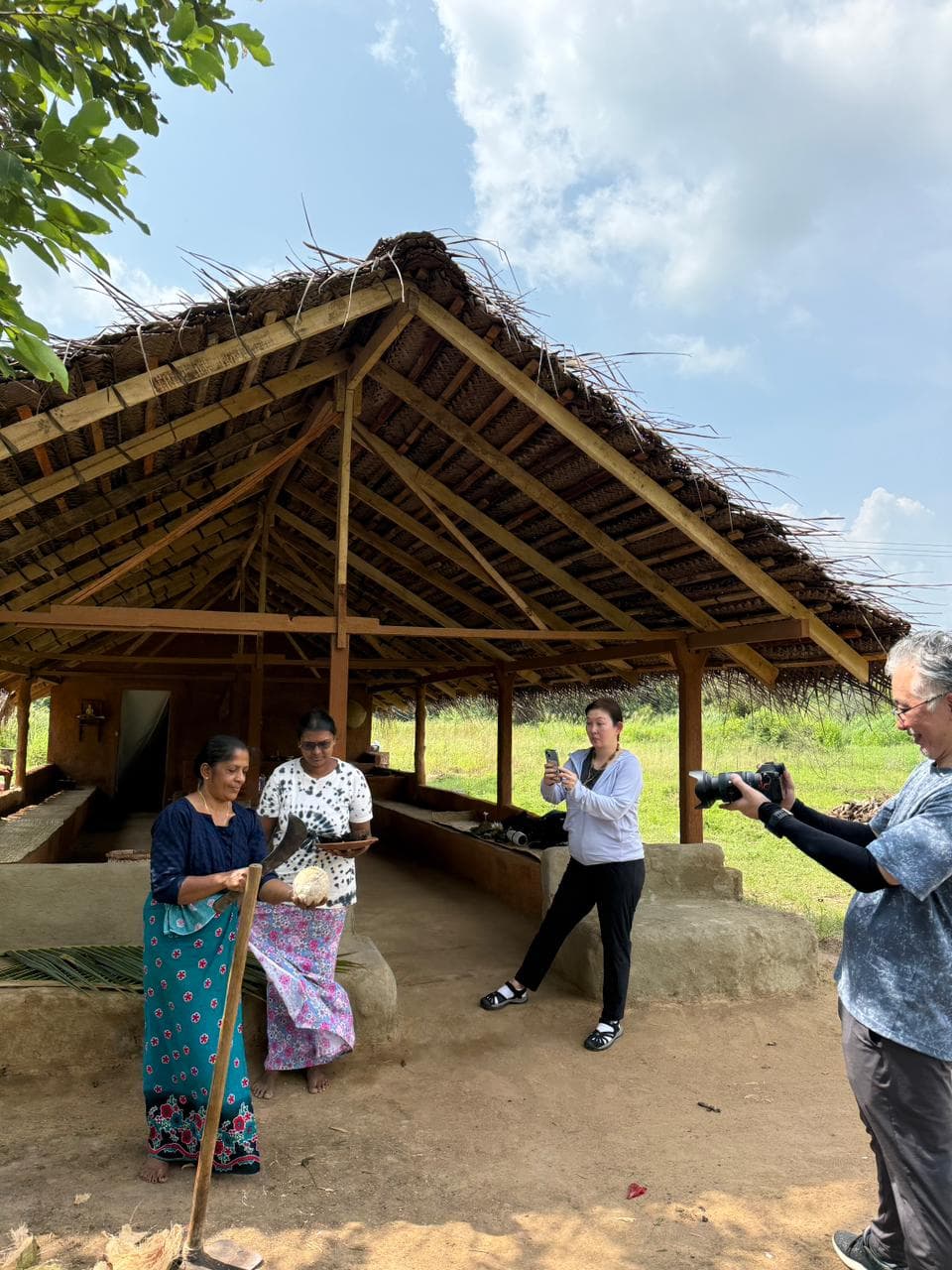 Local hosts demonstrating traditional coconut preparation to travellers
