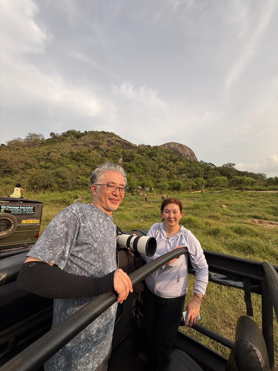 Travellers photographing wildlife from a safari jeep